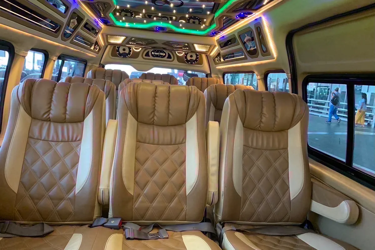 The cabin of the regular Minivan, photographed from the sliding door: three seats side by side across the width of the van with a belt on each, and two more rows of three behind them.